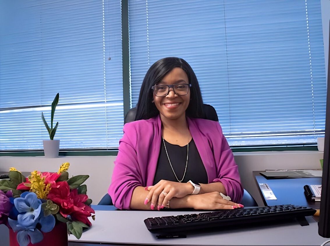 Dr. Lilly Mbinglo smiling at her desk