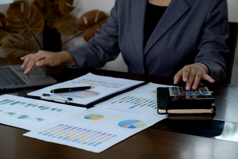 Businesswoman bookkeeper use calculator, and laptops to analyze the graph for Setting business goals